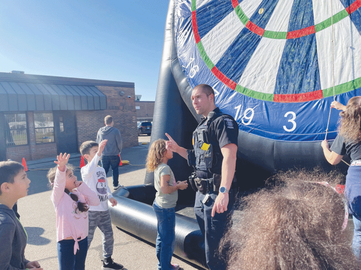  Sterling Heights police officer Jonathan Journeau volunteers at the Day of Awesomeness, which brought inflatable games and obstacle courses to Schwarzkoff Elementary School  as a reward for a fundraiser.  