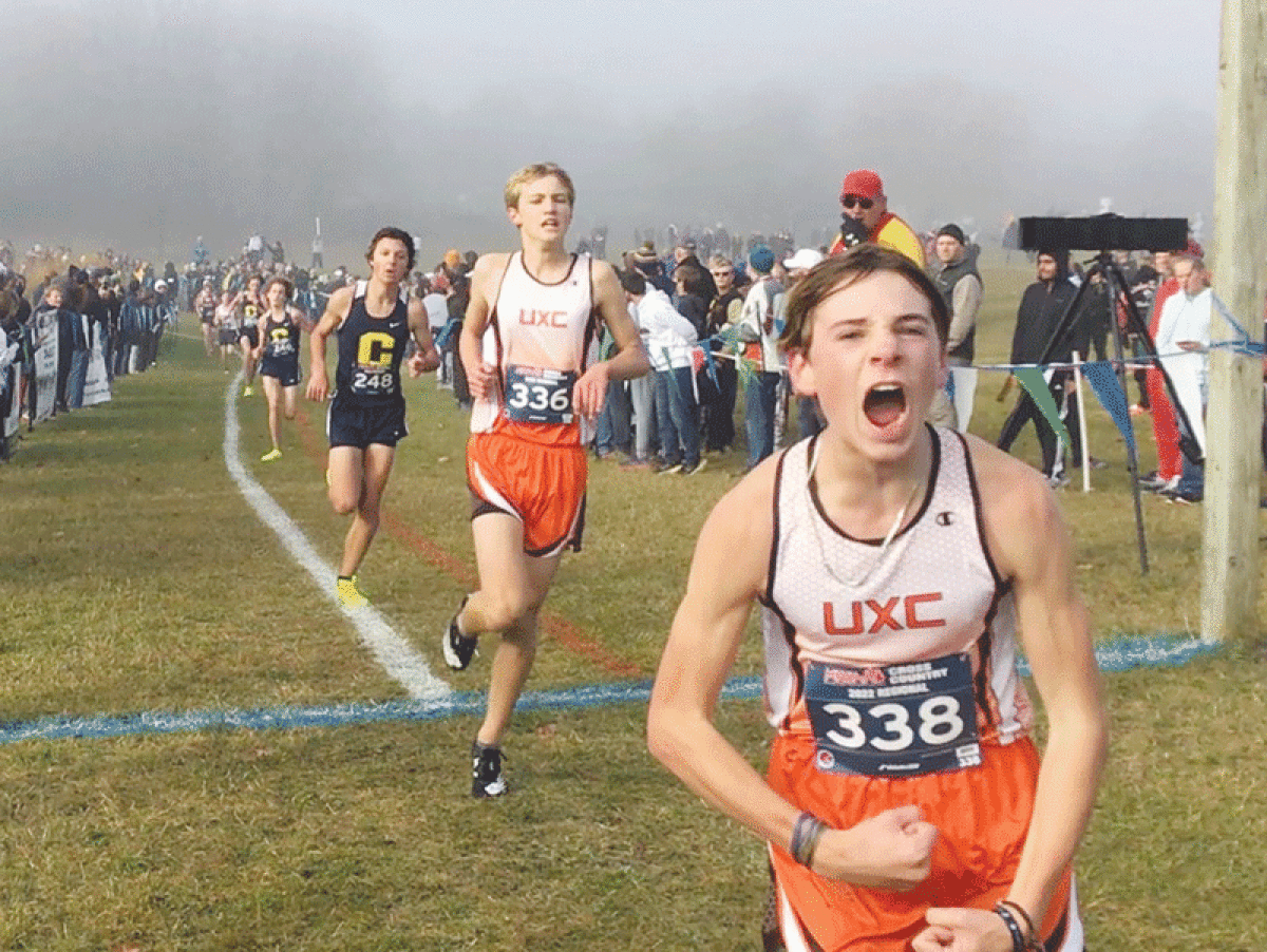   Utica freshman Harper Wesley (No. 338) and sophomore Luke Morehouse (No. 336) celebrate their finishes at the regional meet at Hess Hathaway Park in Waterford Township Oct. 29. 