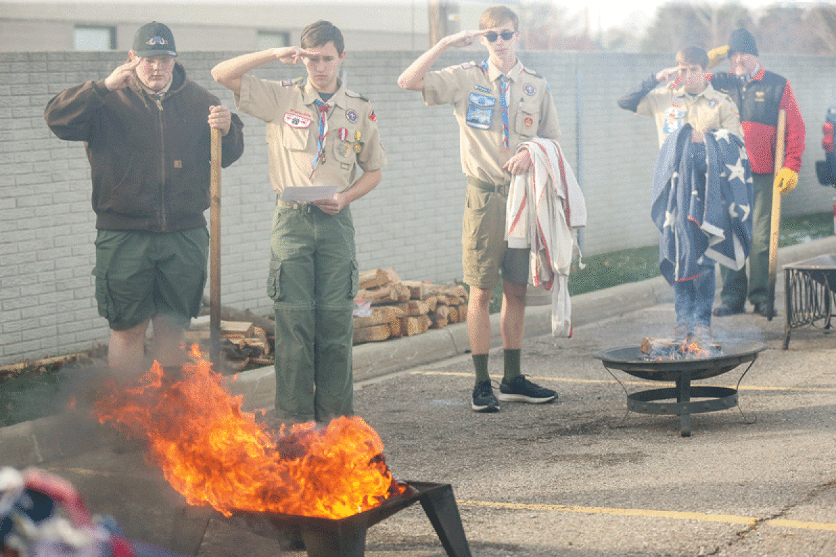  Scouts BSA Troop 209 members Cam Kirsch, Carter Langdon, Senior Patrol Leader Alexander Shunk and Jeremy Salisbury salute as a flag is burned during the retirement ceremony on Nov. 19 in Clinton Township.  