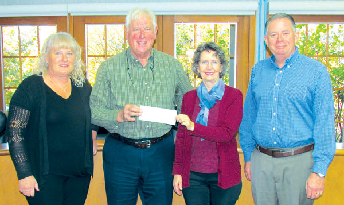  Orchard Lake Clerk Rhonda McClellan, Greater West Bloomfield Historical Society grant writer Christian Sonneville and President Gina Gregory, and Orchard Lake City Services Director Gerald McCallum receive a grant check. The grant helped the historical society continue with its “Our School History” project. 