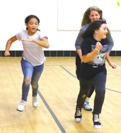  To encourage the students, physical education teacher Jen Warack runs with them during one of their after-school club meetings. 