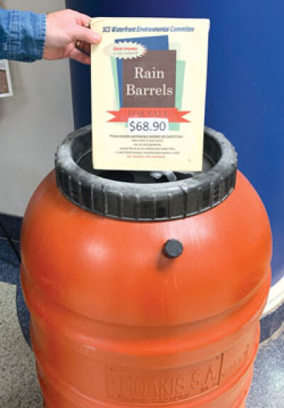  Mark Balon holds a sign showing the price of the rain barrels available for purchase at St. Clair Shores City Hall on Jefferson Avenue at 11 Mile Road. 