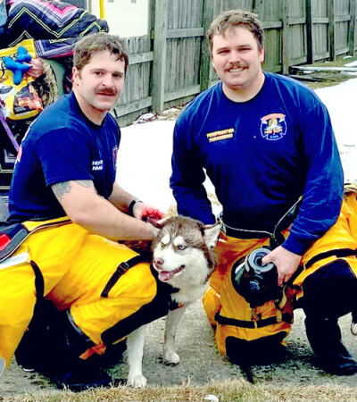  St. Clair Shores firefighters Jamie Maier, left, and Nick McCormick pose with their furry friend after the rescue in late December. 