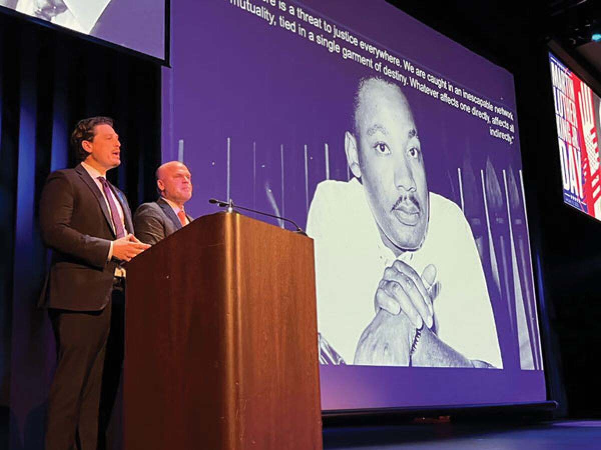  Troy Mayor Ethan Baker, left, and Superintendent Richard Machesky, right, make a presentation at Athens High School’s Martin Luther King Jr. Day celebration Jan. 16. 