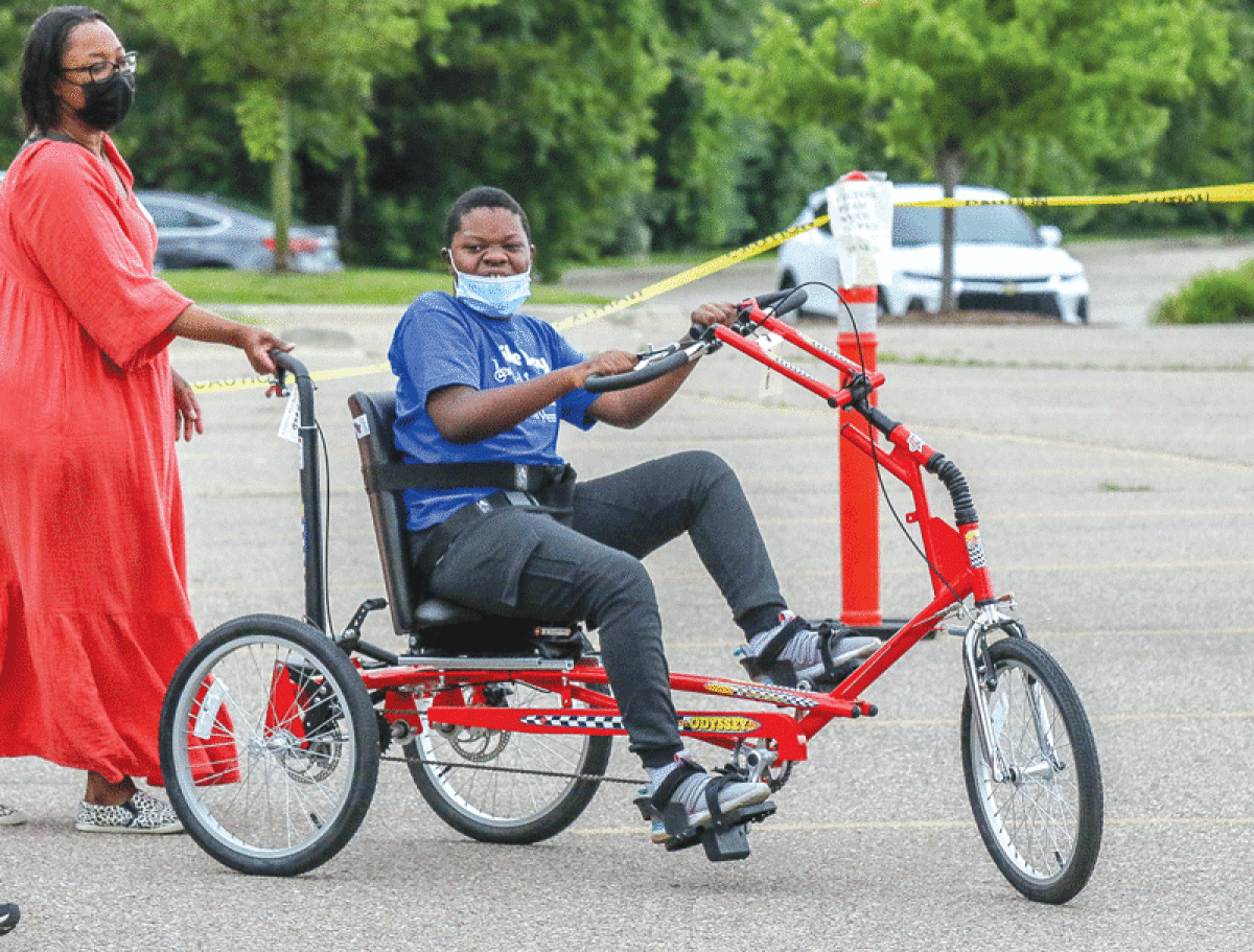  Eleven-year-old Ethan Anthony, of West Bloomfield, can’t contain his smile while trying out his new adaptive bike from Bike Day. 