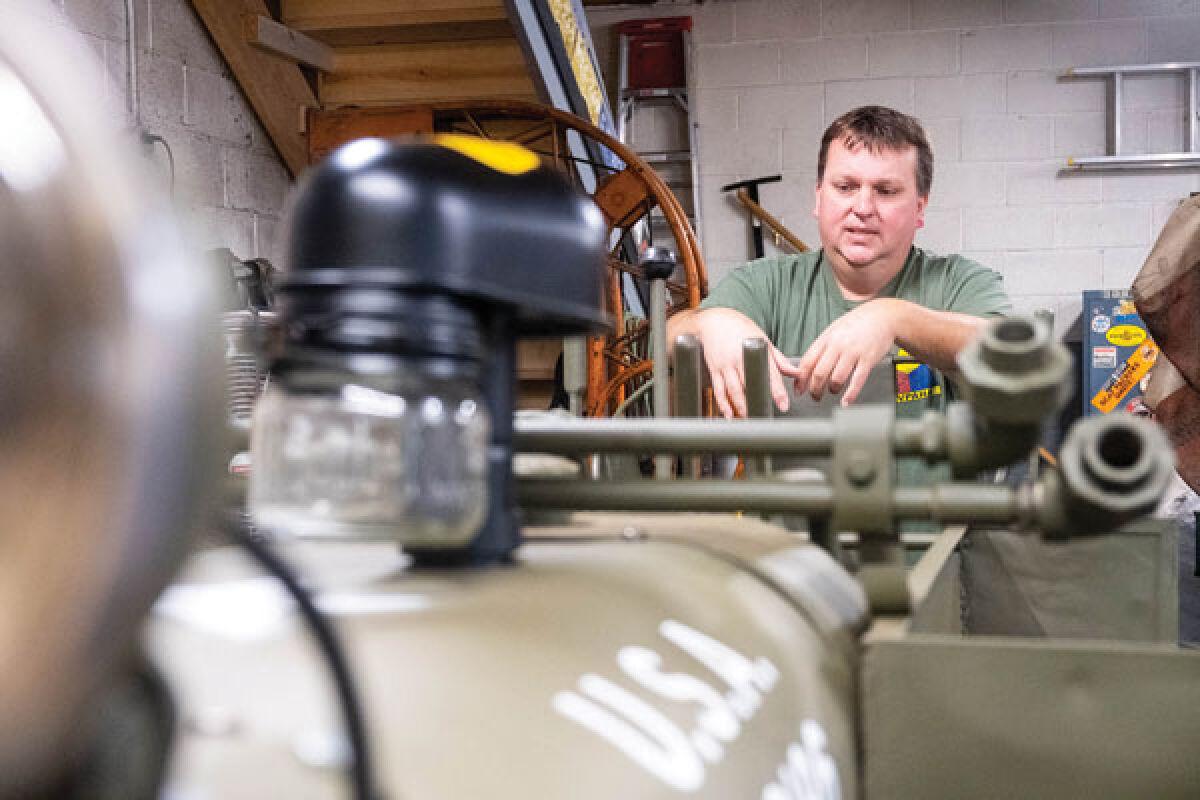  Chris Causley, the executive director of the Michigan Military Technical and Historical Society, talks about a 1944 Clark bulldozer that he’s in the process of restoring Aug. 3 in his St. Clair Shores home. 