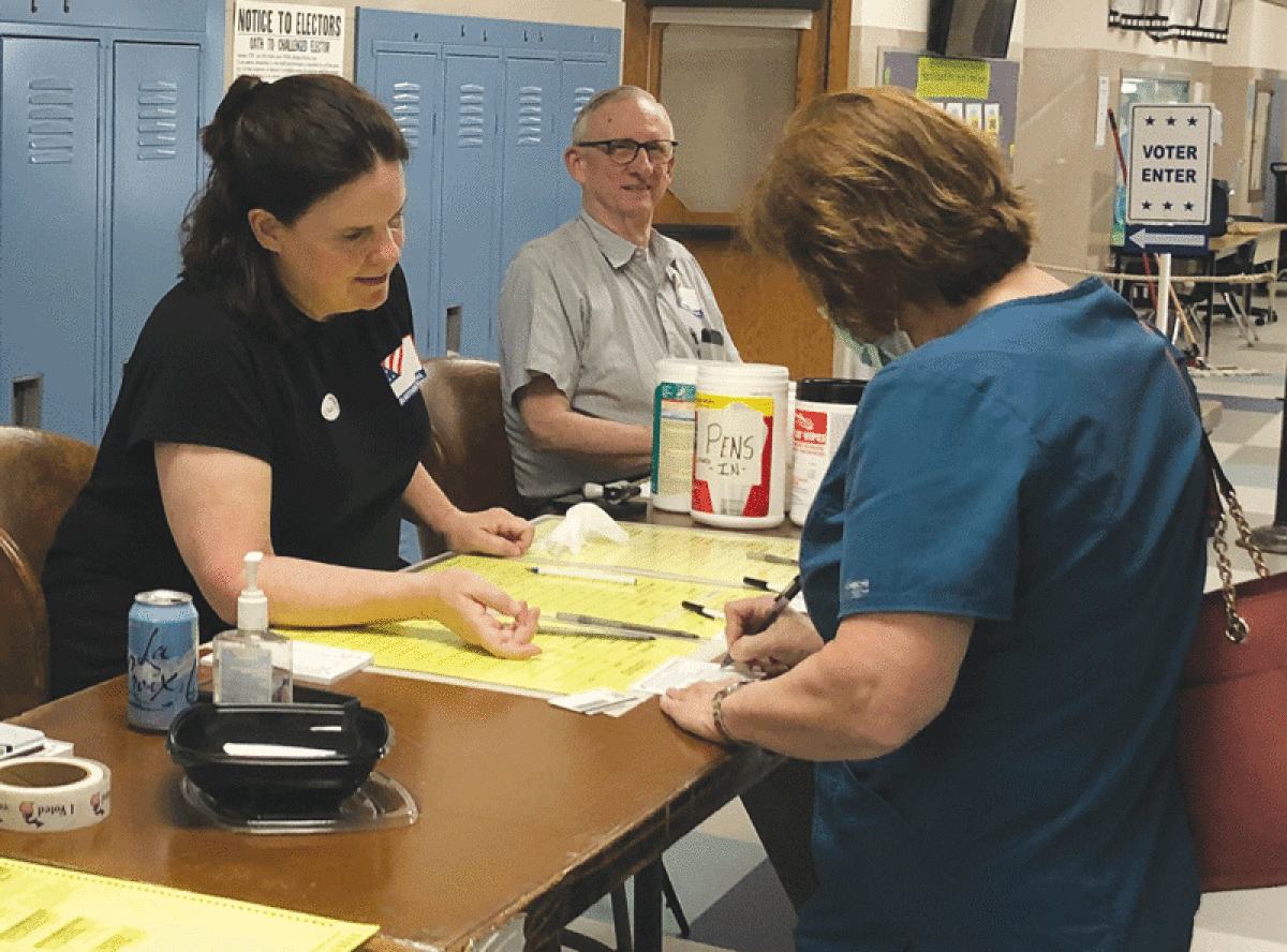  From left, Grosse Pointe City election workers Cathy Victor and Steve Trowbridge assist a voter at Maire Elementary School during the primary election Aug. 2. 