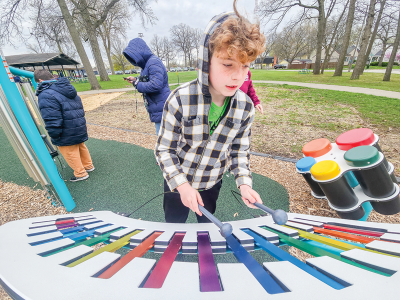  Nathan Roth, 11, of Hazel Park, tries out the xylophone, one of the new musical play elements. 