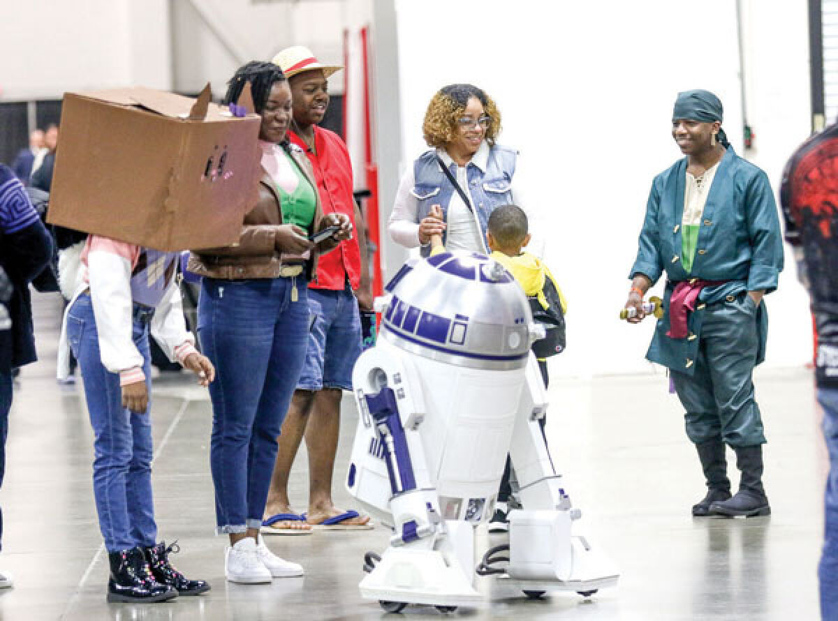  Attendees at the fall 2023 Motor City Comic Con visit with R2-D2 from “Star Wars.” The spring Motor City Comic Con will take place May 17-19 at the Suburban Collection Showplace in Novi. 