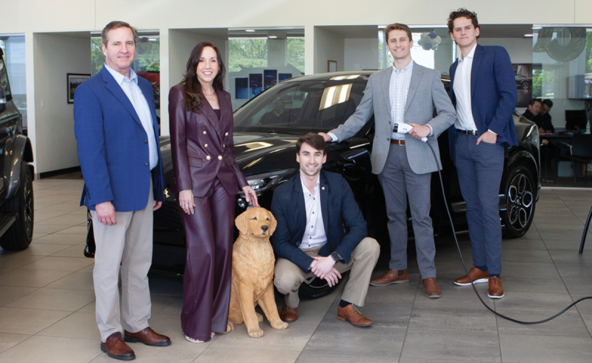  Liz Sellers is pictured with brother Dean Sellers, son Scott Caspersen, nephew Christopher Seller, nephew Adam Sellers and a golden retriever statue, which is one of the many golden retriever artworks featured around the dealership. 