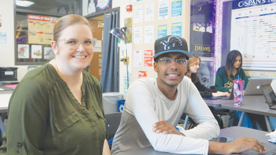  A teacher at Adams High School connects with a student during an AP class. RCS offers an AP Capstone Diploma, where students must successfully pass both AP Seminar and AP Research with a score of 3 or higher, as well as four other AP exams with a score of 3 or higher. 