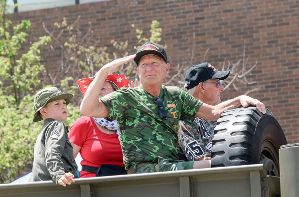  Campbell Fox, 8, of Grosse Pointe Park, rides in the parade with his grandfather, Roger Fox, 77, of Roseville, center, and Mick DeKeyser, right, during the St. Clair Shores Memorial Day Parade in 2023. Both Roger Fox and DeKeyser are Vietnam veterans. 