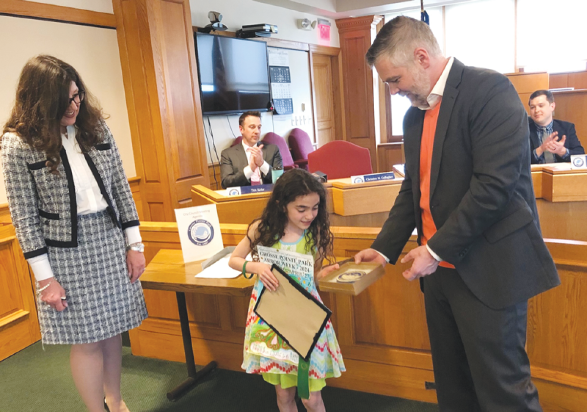  From left, Grosse Pointe Park Mayor Michele Hodges looks on as poster contest runner-up Cecily Filippone is presented with a city tile by City Councilman Brent Dreaver. 