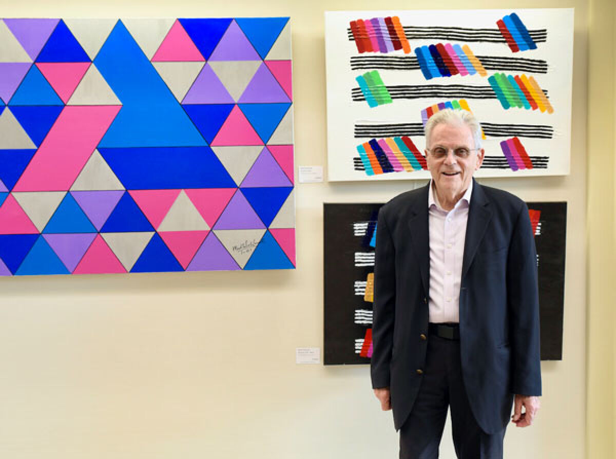  Southfield resident Mark Schlussel poses next to his three pieces shown in the exhibit: “Triangulation,” “Song of Color” and “Song of Color Mirror.” 