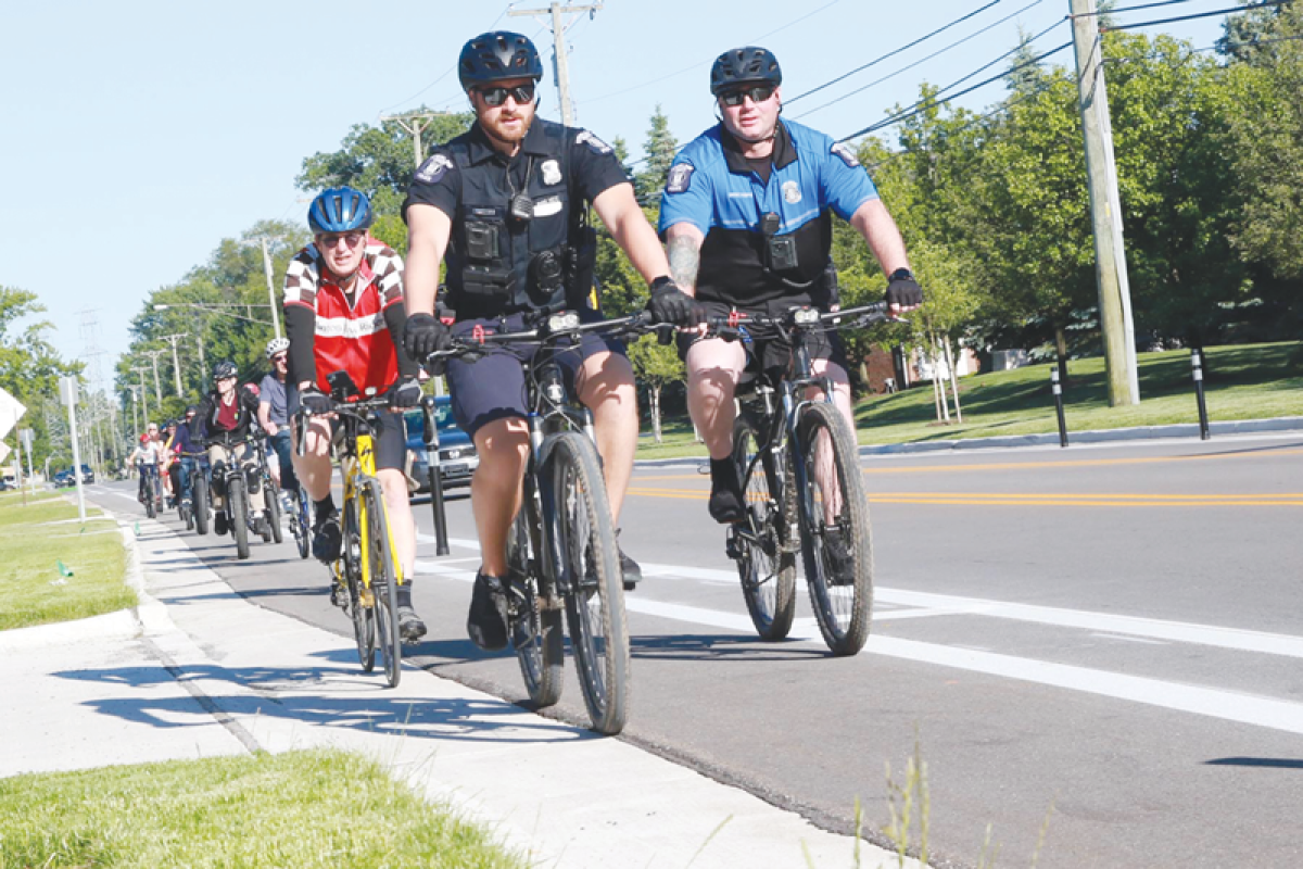  Sterling Heights police ride along the new bike lane on Plumbrook Road as part of a May 30 event celebrating the new amenity’s completion.  