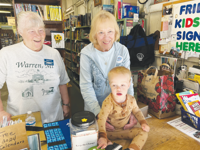  The Friends of the Warren Public Library Bookstore attracts readers of all ages.  Louis Speelman, 18 months, flips through one of the many children’s books with Kathy Tasich, co-chair of the bookstore, and Naida Okray, board president.  