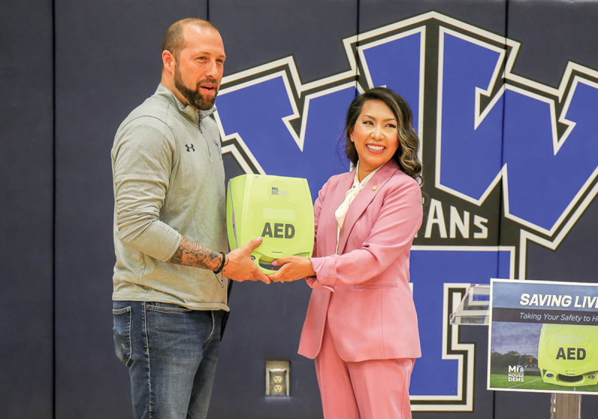  On May 24, state Rep. Mai Xiong, D-Warren, right, presented an automated external defibrillator to Warren Woods Tower High School Assistant Principal Josh Thelen, left. 