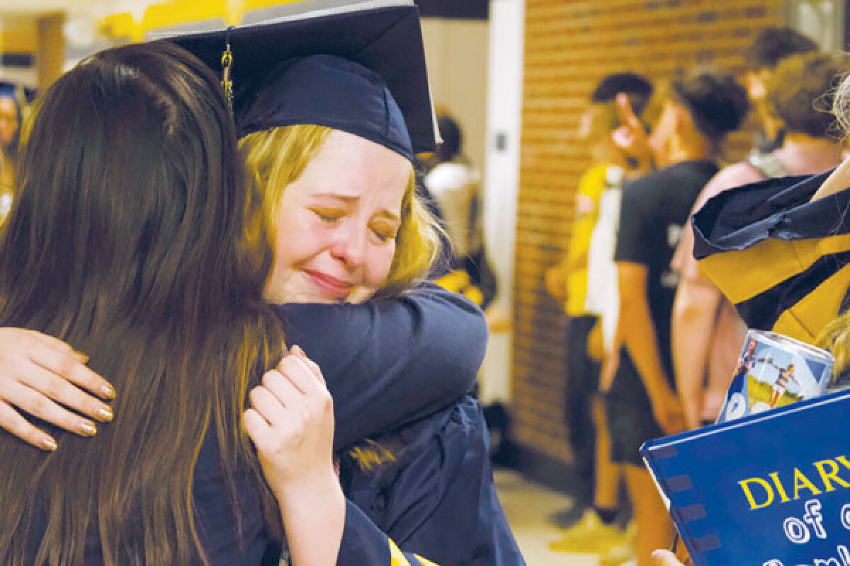  Senior Codenne Fleming hugs teacher Sonja Bozinovski during the senior walk on May 24 at Fraser High School. 