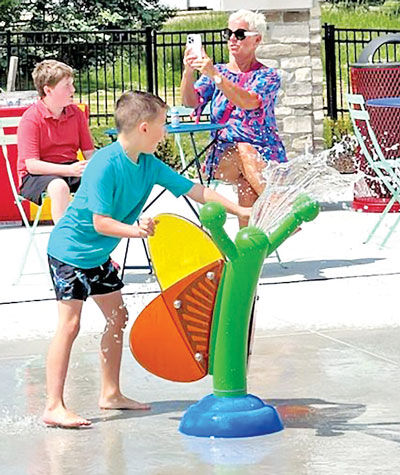  A boy plays with a water cannon during the private opening of Jessica’s Splashpad. 