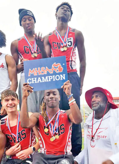  Clinton Township Chippewa Valley senior Shamar Heard holds up the state championship sign around his teammates on June 1 at East Kentwood High School. 