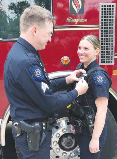  Grosse Pointe Farms Public Safety Sgt. Timothy Harris pins the badge on the uniform of his wife, Paige Thomas, after she’s sworn in as a Farms Public Safety officer. 