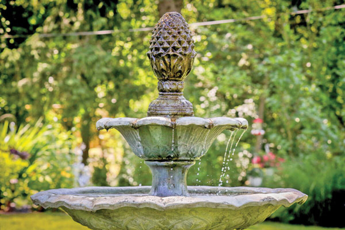  A fountain in the front yard is one of three in Sharon and Joseph Ensley’s gardens. 