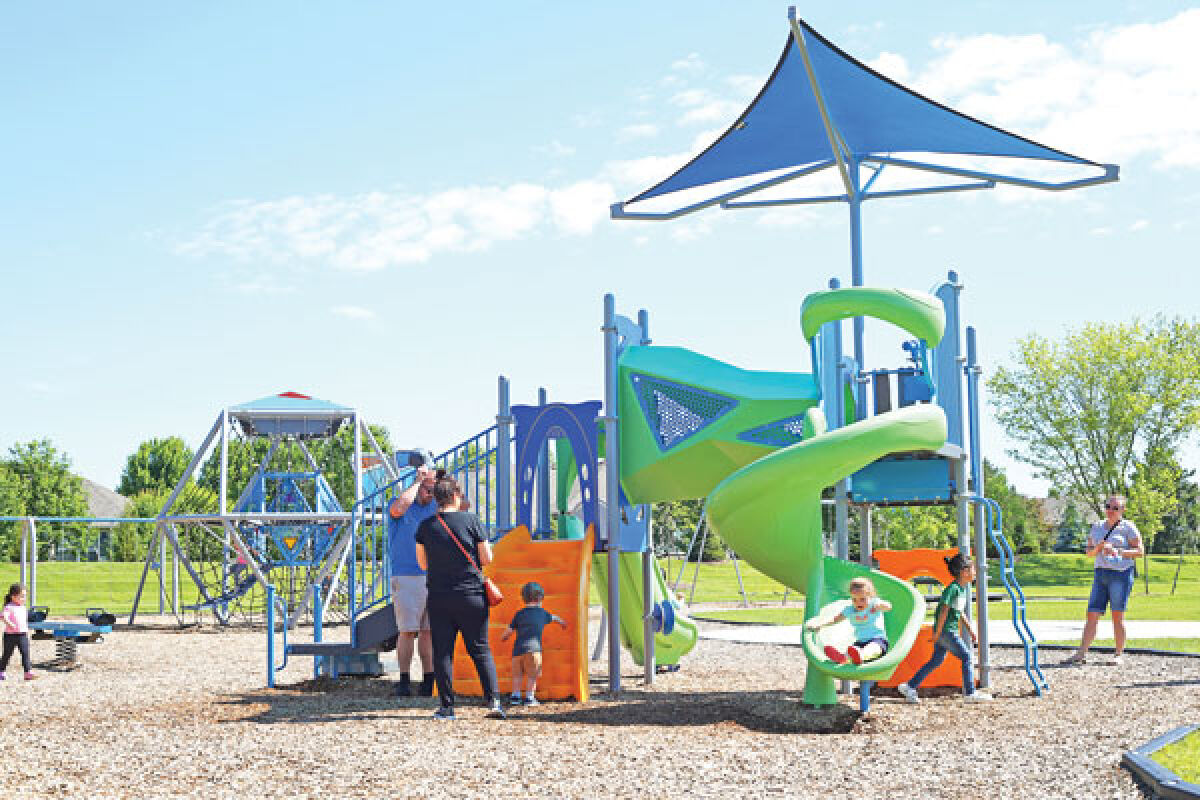  Parents watch as kids play on the Pitchford Park playground on June 9.  