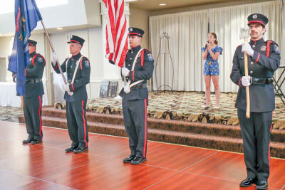  Amelia Kowalski sings the national anthem for guests as the St. Clair Shores Fire Department Honor Guard stands at attention holding the flags of the United States and the state of Michigan. 