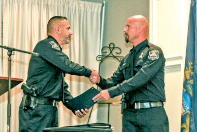  Deputy Police Chief Paul Plaza hands police officer David Ealy a valor award at the appreciation breakfast for the St. Clair Shores Police Department and the St. Clair Shores Fire Department. 
