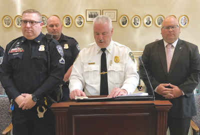  At left, Grosse Pointe Woods Public Safety officer Dennis Walker and Sgt. Joseph  Provost and, at right, Detective Ryan Schroerlucke, listen as Woods Public Safety Director John Kosanke, center, discusses their award for apprehending a couple of bank robbers. 