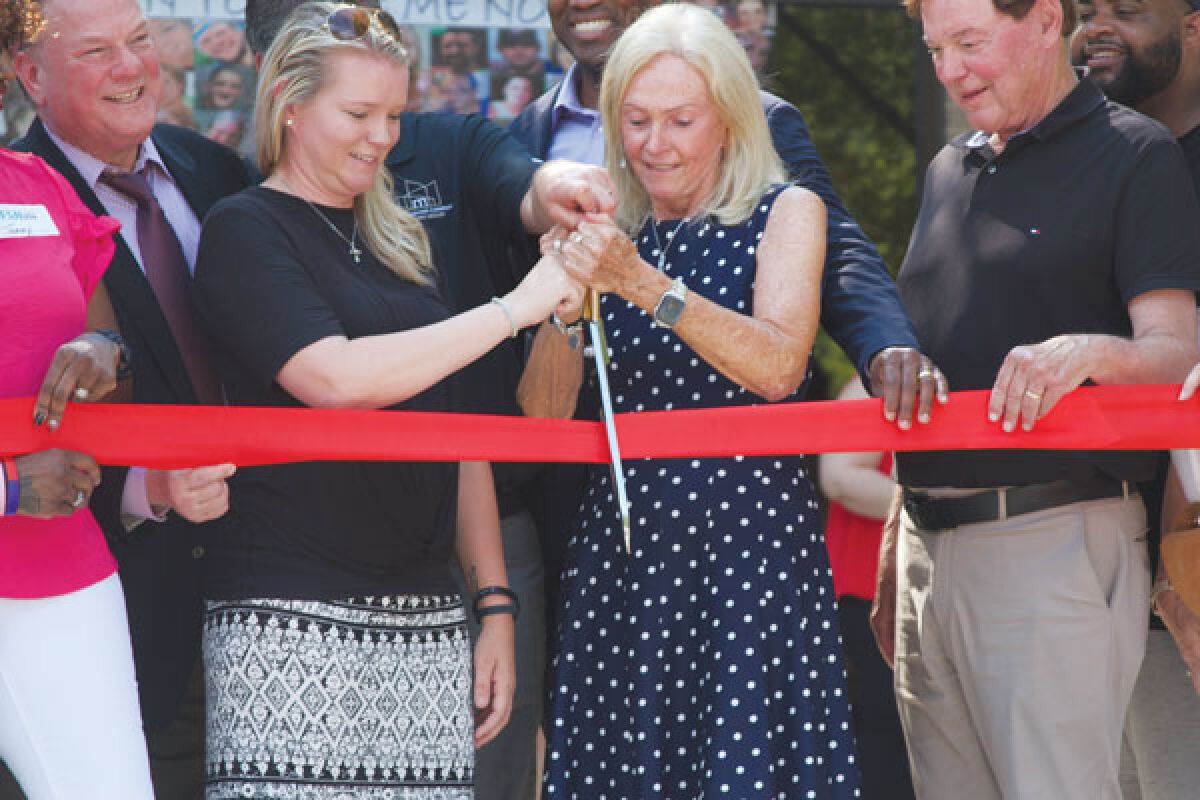  Linda Davis, cofounder of FAN, cuts the ribbon to celebrate Face Addiction Now’s new offices in Clinton Township on June 17. 