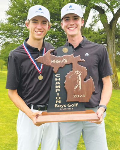  Detroit Catholic Central sophomores David Krusinski, left, and Jack Whitmore hold the MHSAA Division 1 state title trophy. 