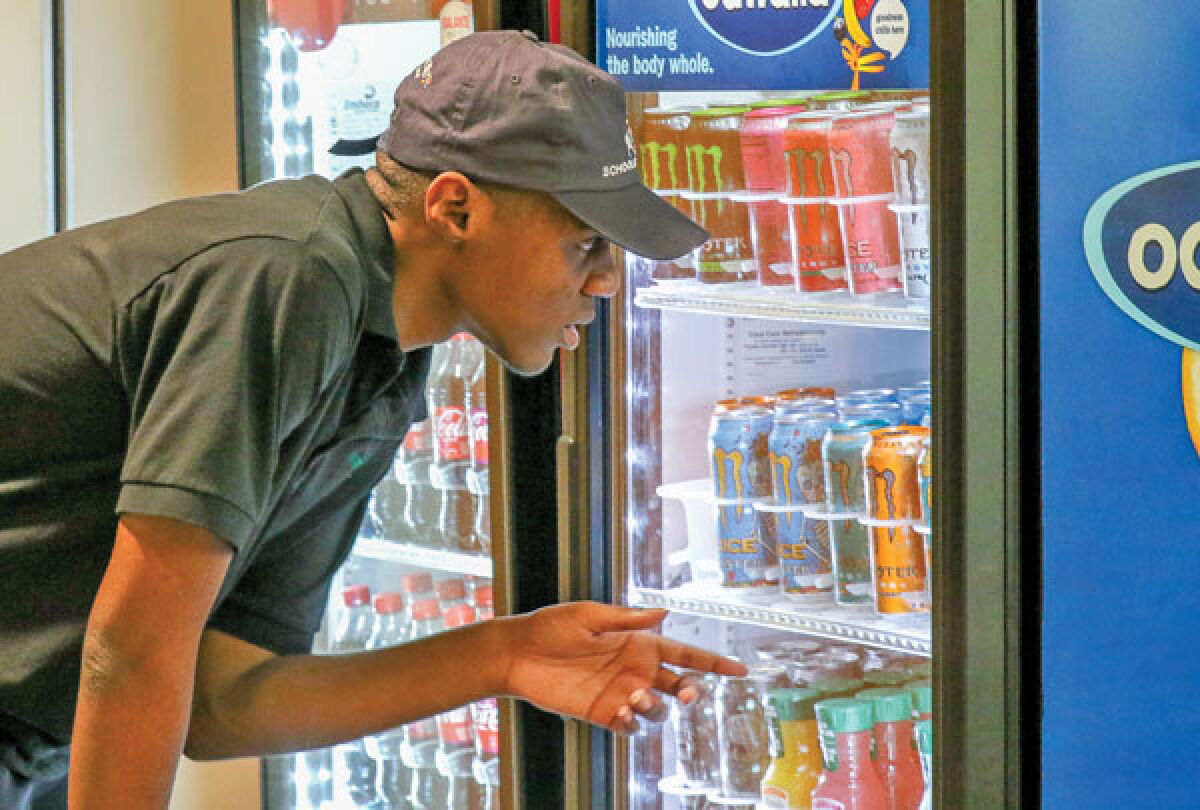  Archie McPherson takes inventory of the cooler at the Novi Public Library Cafe May 10, where he volunteers as part of the Novi Adult Transition Center’s work-based learning program. 