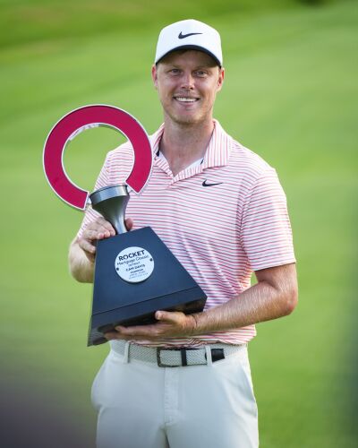  Cam Davis hoists the Rocket Mortgage Classic trophy for the second time in his career after finishing in first with a score of 18 under on June 30 at Detroit Golf Club.  