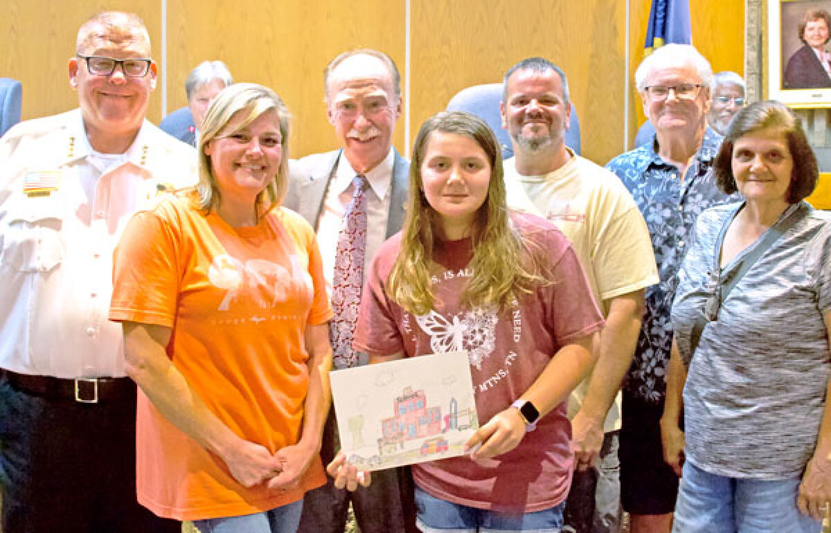  Rylee Tilney, center, winner of Roseville’s National Night Out poster contest, poses for a picture with her family, Roseville Police Chief Mitch Berlin, far left, and Roseville Mayor Robert Taylor, third from left.  