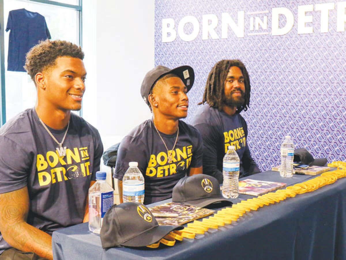  Michigan Wolverines football players Donovan Edwards, right, Semaj Morgan, center, and Will Johnson, left, sign autographs for fans at a meet-and-greet event July 9 at the Born in Detroit store on Woodward Avenue in downtown Detroit. 