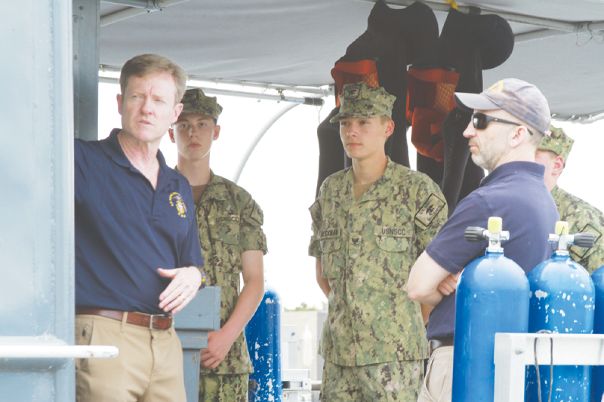  Andrew Lennon, executive director of United States Naval Sea Cadet Corps and a retired U.S. Navy rear admiral, speaks with cadets near the stern of the Pride of Michigan on June 28. Lennon stopped by the ship as part of a larger tour of the USNSCC’s programs across the United States and territories. 