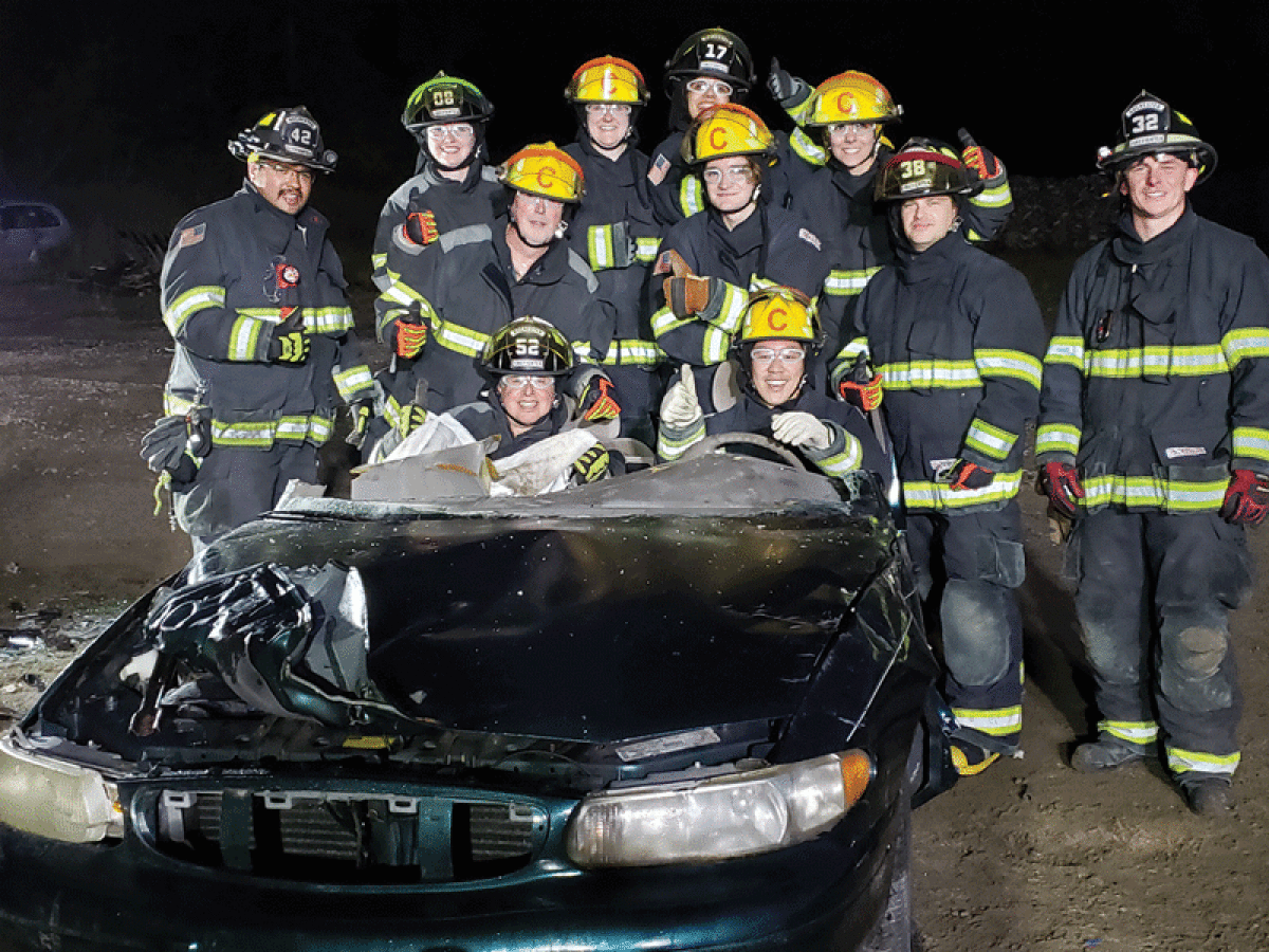  Past Rochester Citizens Fire Academy participants pose for a photo after using tools for a car rescue. 