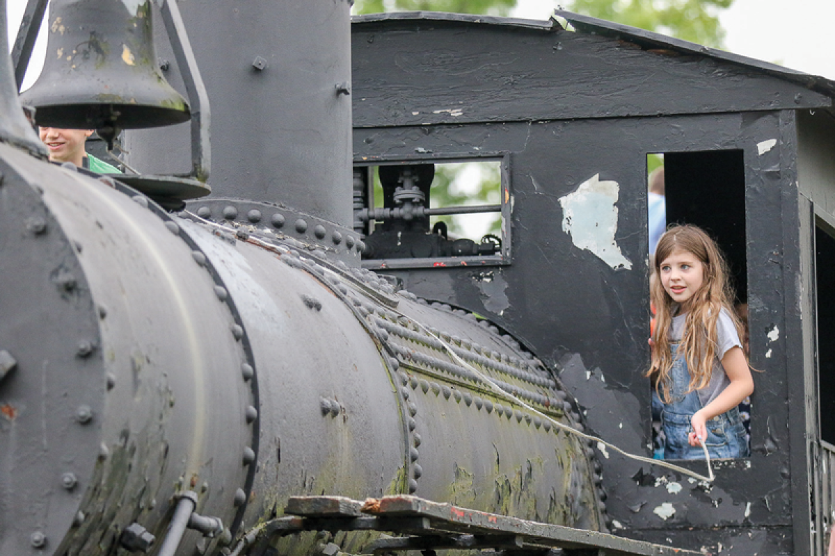  Quinn Oparka, 9, of Shelby Township, rings the bell from the cab of the 1920 steam locomotive on permanent display at the township’s municipal campus during Summerfest June 28.  