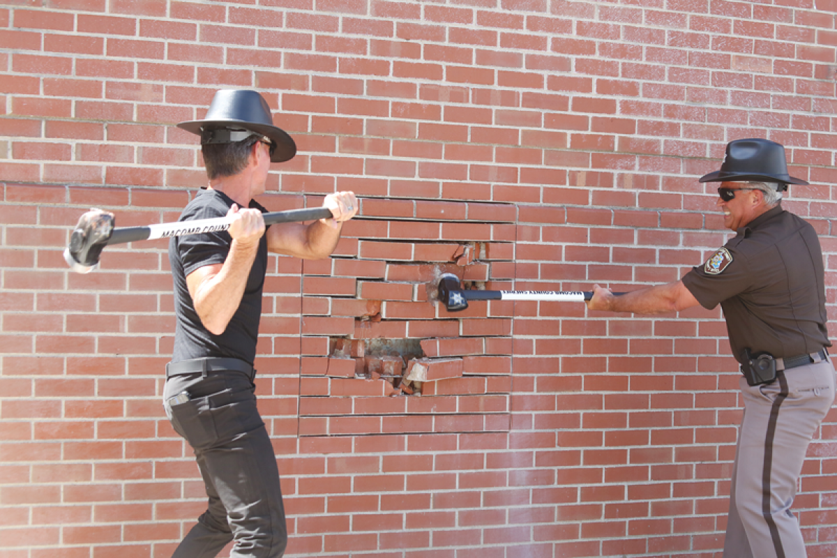  Macomb County Executive Mark Hackel, left, and Macomb County Sheriff Anthony Wickersham drive sledgehammers into the Jail Annex building on July 19. The ceremonial demolition, followed by the start of the actual demolition on July 22, is the latest step in the construction of the new central intake and assessment center. 