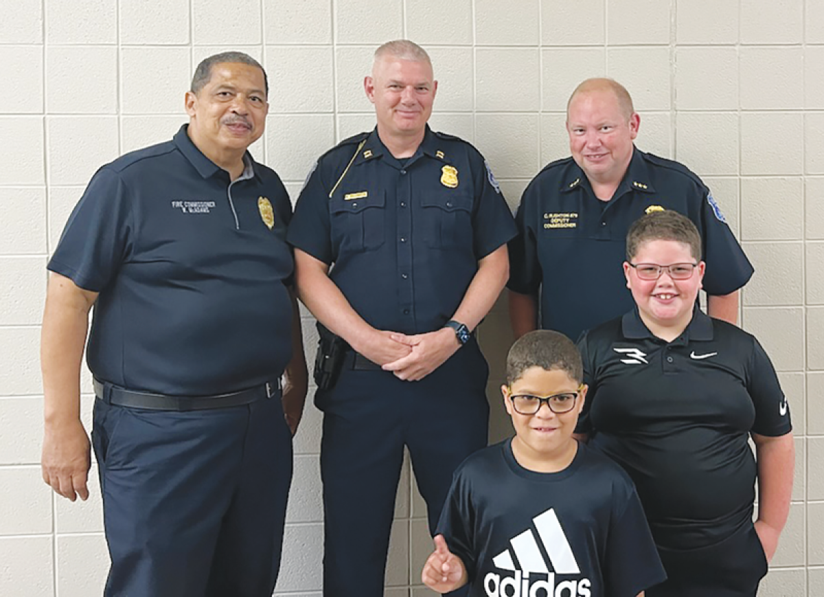  Warren police and firefighters congratulated Chance Mason, in the middle row, for saving the life of his youngerbrother Jaxon Mason, in the front row. 