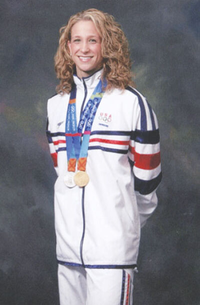  Rachel Baugh, known as Rachel Komisarz during her 2004 Olympic run, poses for a photo with her Olympic medals. 