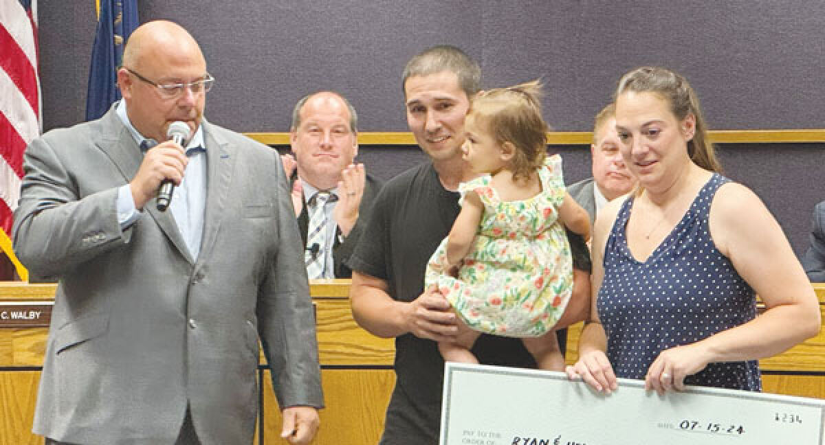  The Kemp family receives the money raised by the Pizza Palooza event from Bryan Owens, a member of the St. Clair Shores Optimist Club and the creator of Pizza Palooza. 