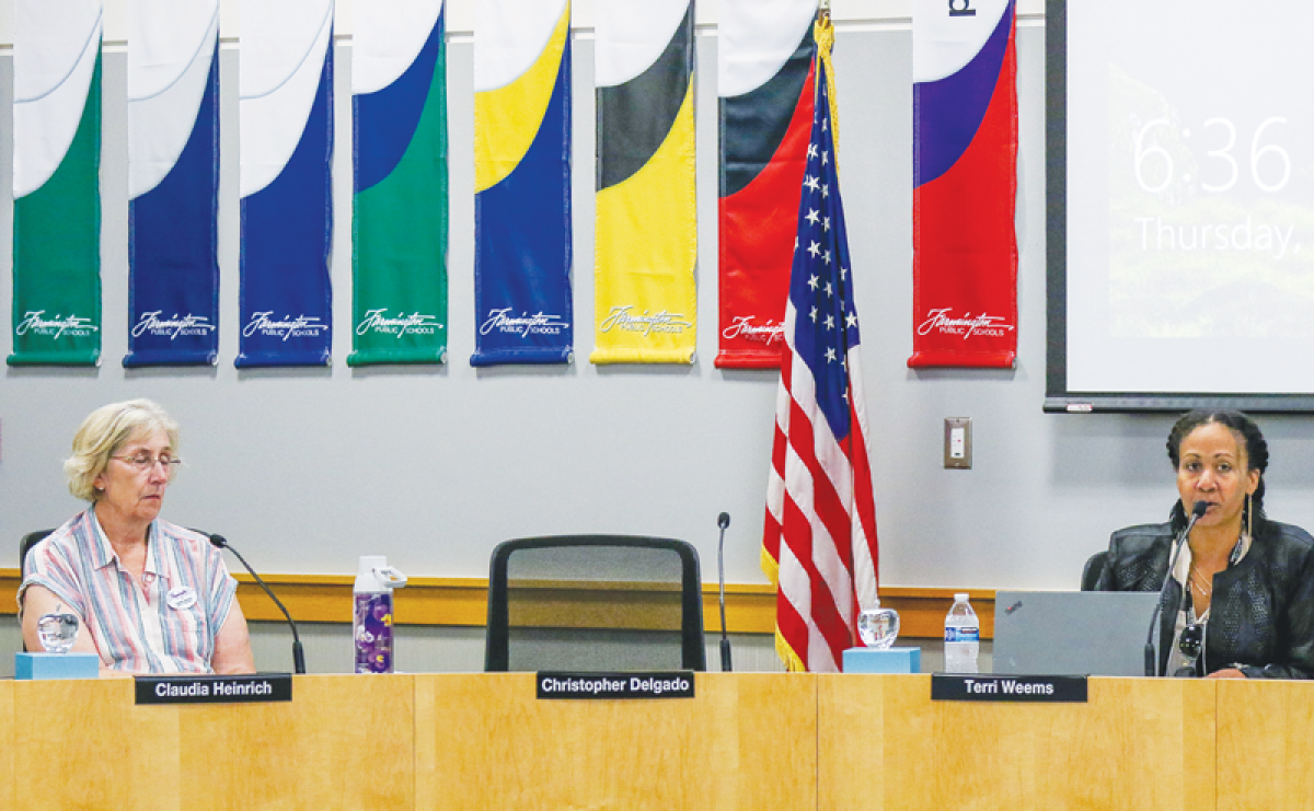  Superintendent Christopher Delgado’s chair is noticeably empty as Board President Terry Weems and Board member Claudia Heinrich engage in conversation on how to best fill his pending vacancy  during a special board meeting July 25.   