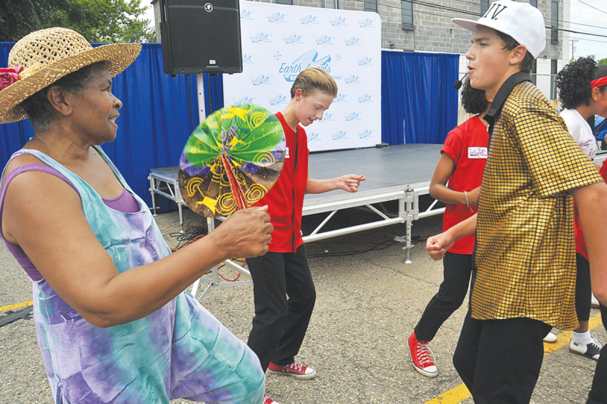  The 60th edition of the Farmington Founders Festival took place in downtown Farmington July 18-20. Farmington Hills resident Patricia Hayes-Hall dances as Jake Planowski, center, and Jack Johnson, who are part of a performing arts troupe, perform. 