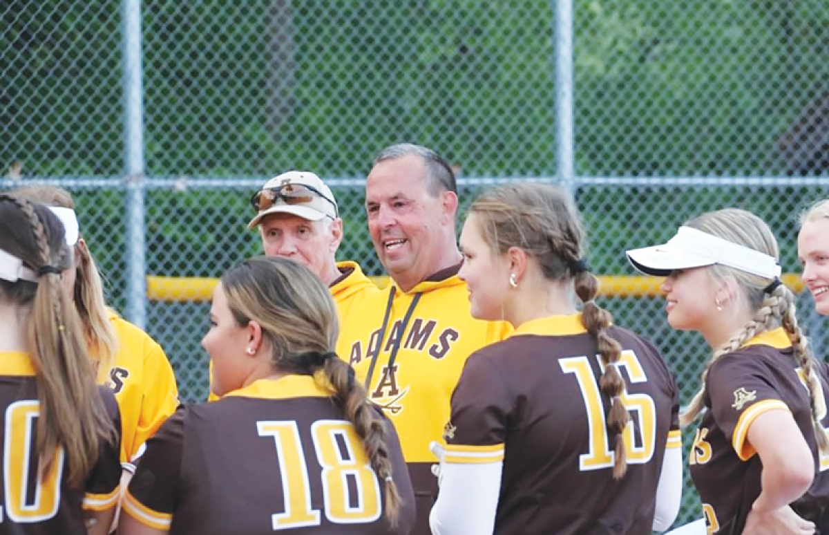  Longtime Rochester Adams softball head coach Fran Scislowicz smiles while standing with his team.  