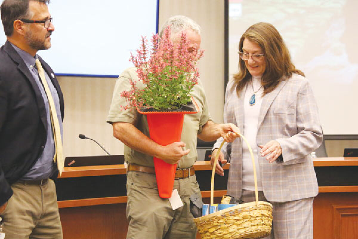  Macomb Township Treasurer Leon Drolet, obscured in center, presents state Sen. Veronica Klinefelt, D-Eastpointe, with gifts of flowers and a basket of caffeinated drinks at the July 24 township board meeting. Trustees thanked Klinefelt for securing $3 million for reworking an intersection, which made it into the state’s 2024-25 education budget signed earlier that day. 