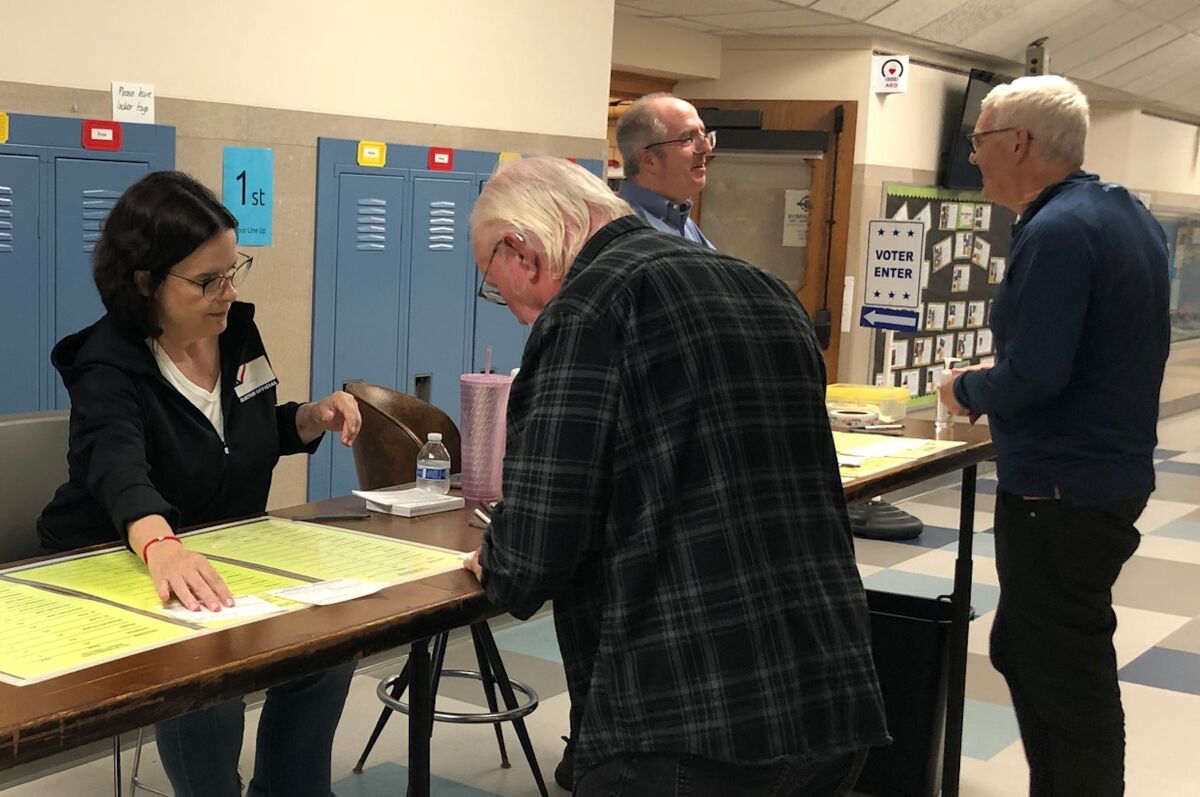  Grosse Pointe City election workers Cathy Victor and Bill Rooney assist voters at the information desk at Maire Elementary School during the primary Aug. 6. 