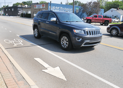  An example of a shared lane marking, or “sharrow,” denoting bike lanes on south John R Road near the Eastern Palace Club. Similar sharrows are being installed along the north end of John R Road as the road diet continues. 