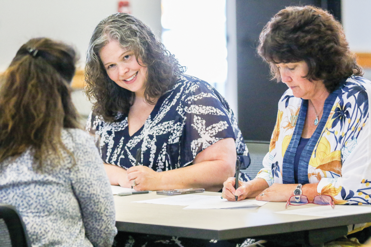  Lydia Moore, executive director of special education for Farmington Public Schools, and Dorene Forster, the principal of Visions Unlimited, interview a candidate for a parapro position during the job fair July 26 at the Maxfield Education Center in Farmington.   